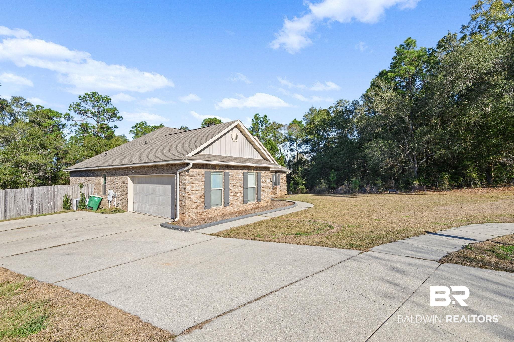7506 Carlson Court Mobile, AL 36619 - Photo 4 of 33 View of property exterior with brick siding, concrete driveway, an attached garage, and roof with shingles