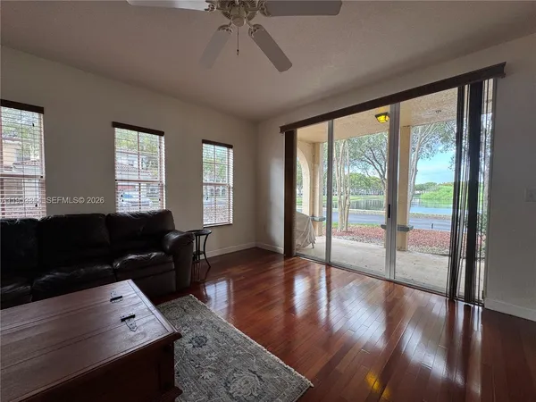 a living room with hardwood floor and a window