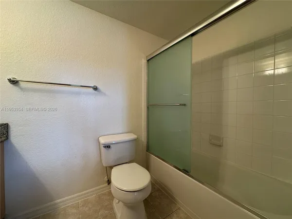 a bathroom with a granite countertop toilet and a sink