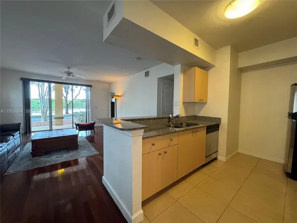 a kitchen with stainless steel appliances kitchen island granite countertop a refrigerator a stove and a sink