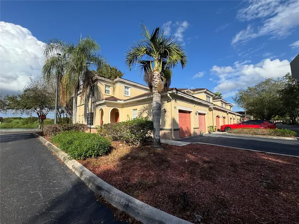 a front view of a house with a yard and potted plants
