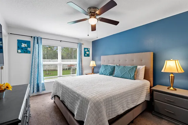 a bedroom with a bed and a flat tv screen on dresser