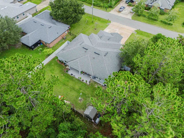 an aerial view of residential house with outdoor space and trees all around