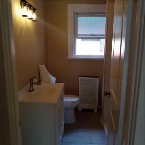 a bathroom with a toilet sink and mirror