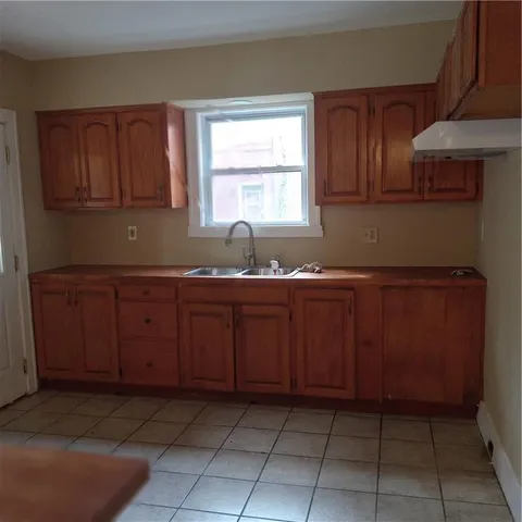 a kitchen with granite countertop a sink a stove and cabinets