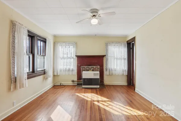 a view of an empty room with a fireplace and a window
