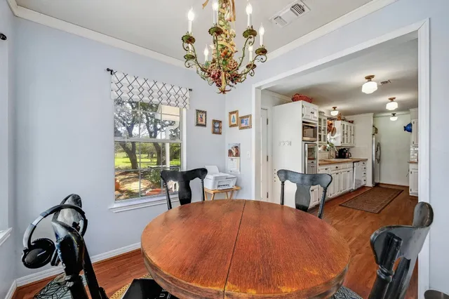 a view of a dining room with furniture and chandelier