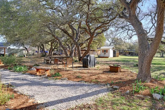 a view of a house with backyard and trees