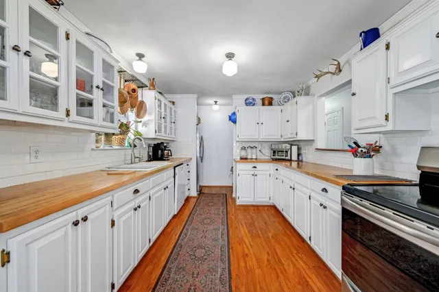a large kitchen with stainless steel appliances lots of counter space and wooden floor