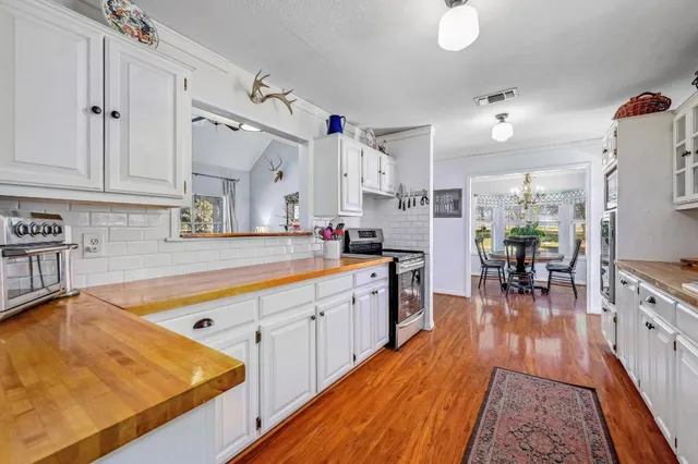 a large kitchen with lots of counter top space and wooden floor