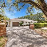 a view of house with backyard and a tree
