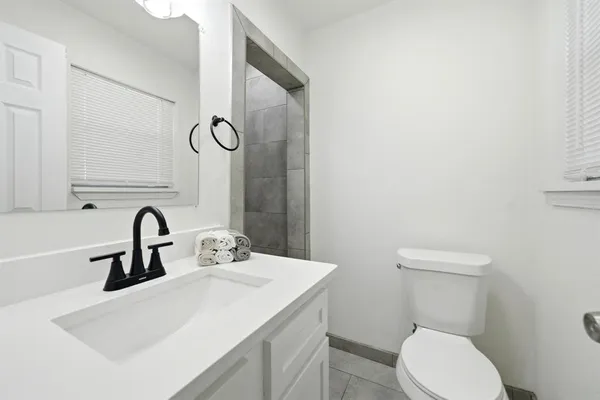 a bathroom with a toilet sink and mirror