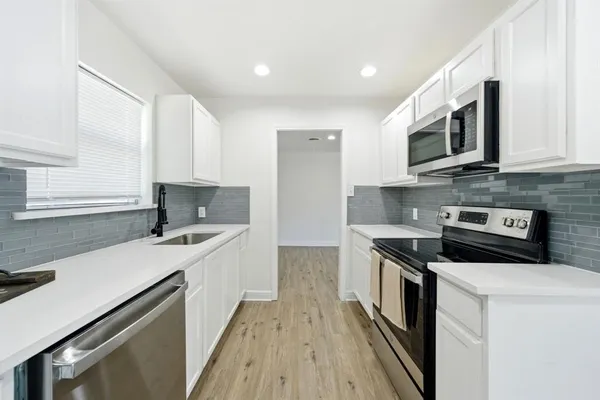 a kitchen with stainless steel appliances a sink dishwasher stove and microwave