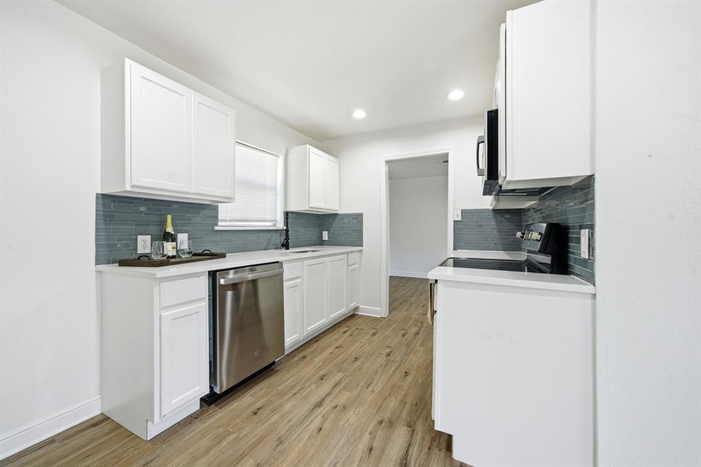 619 9th Street Terrell, TX 75160 - Photo 8 of 24 a kitchen with granite countertop white cabinets and white appliances