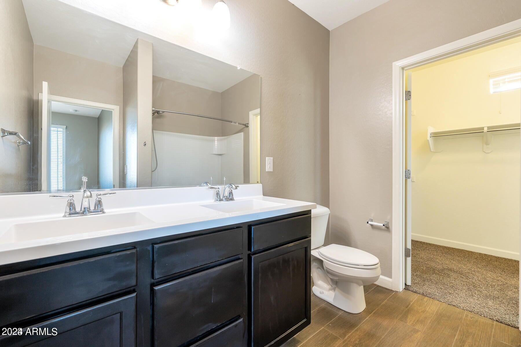 2150 West Alameda Road, Unit 1169 Phoenix, AZ 85085 - Photo 15 of 26 a bathroom with a granite countertop toilet sink and mirror