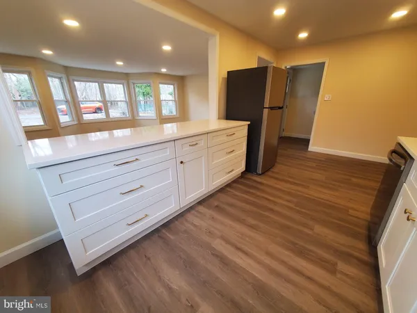 a view of a kitchen with cabinets and wooden floor