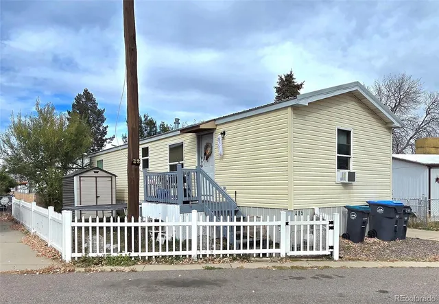 a view of a house with a small yard and wooden fence
