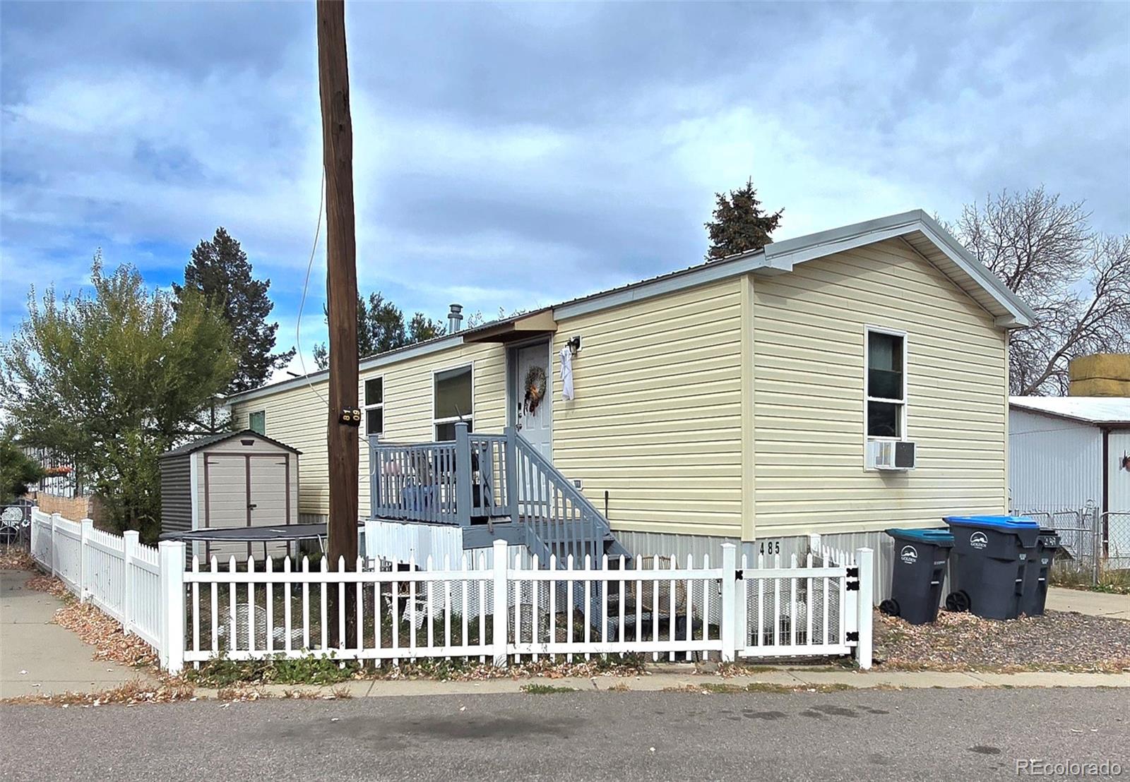 a view of a house with a small yard and wooden fence