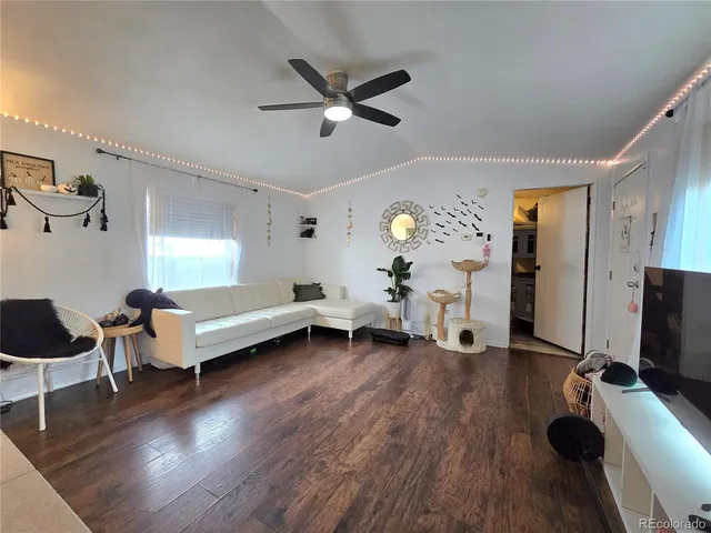 a living room with furniture and a wooden floor
