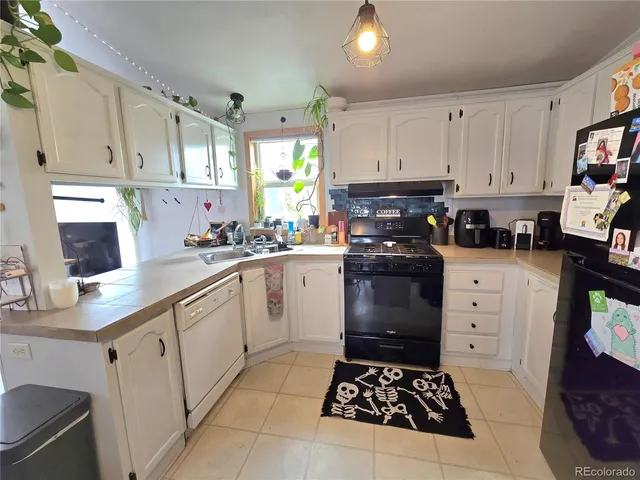 a kitchen with white cabinets and appliances