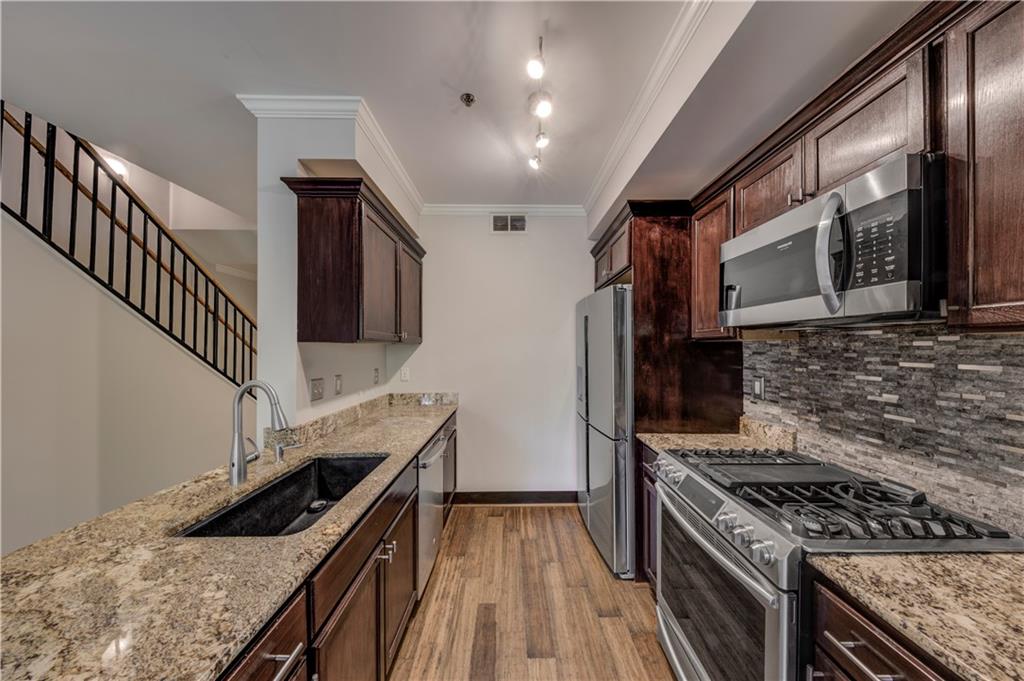 2626 Peachtree Road Northwest, Unit 412 Atlanta, GA 30305 - Photo 15 of 38 a kitchen with granite countertop a stove and a wooden floor