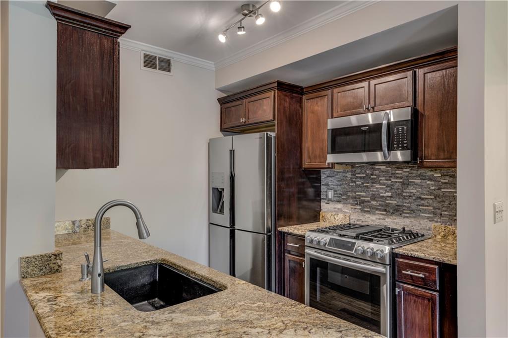 2626 Peachtree Road Northwest, Unit 412 Atlanta, GA 30305 - Photo 16 of 38 a kitchen with granite countertop a stove and a refrigerator