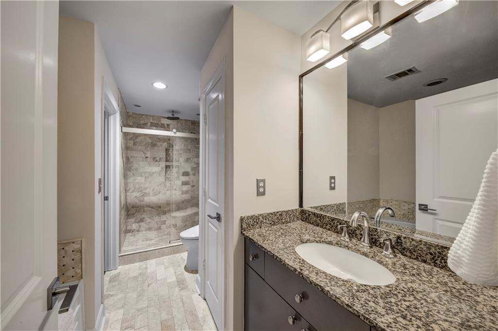 2626 Peachtree Road Northwest, Unit 412 Atlanta, GA 30305 - Photo 22 of 38 a bathroom with a granite countertop sink double vanity and a mirror