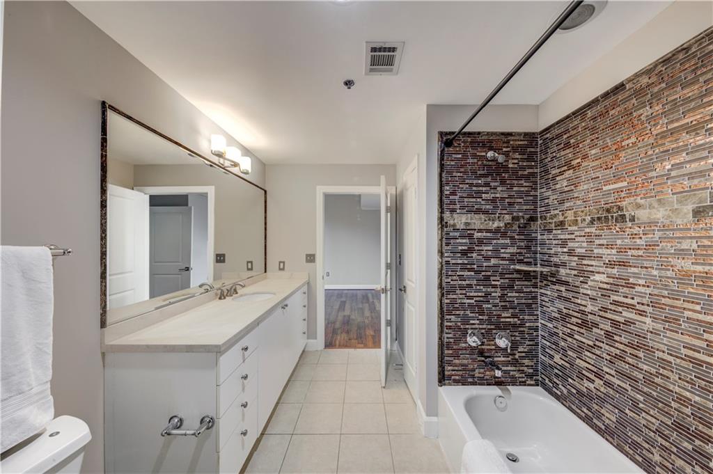 2626 Peachtree Road Northwest, Unit 412 Atlanta, GA 30305 - Photo 29 of 38 a bathroom with a double vanity sink mirror and bathtub