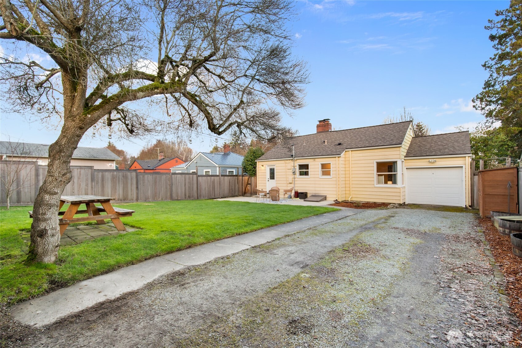8625 35th Avenue Southwest Seattle, WA 98126 - Photo 25 of 33 a view of a white house with a big yard and large trees