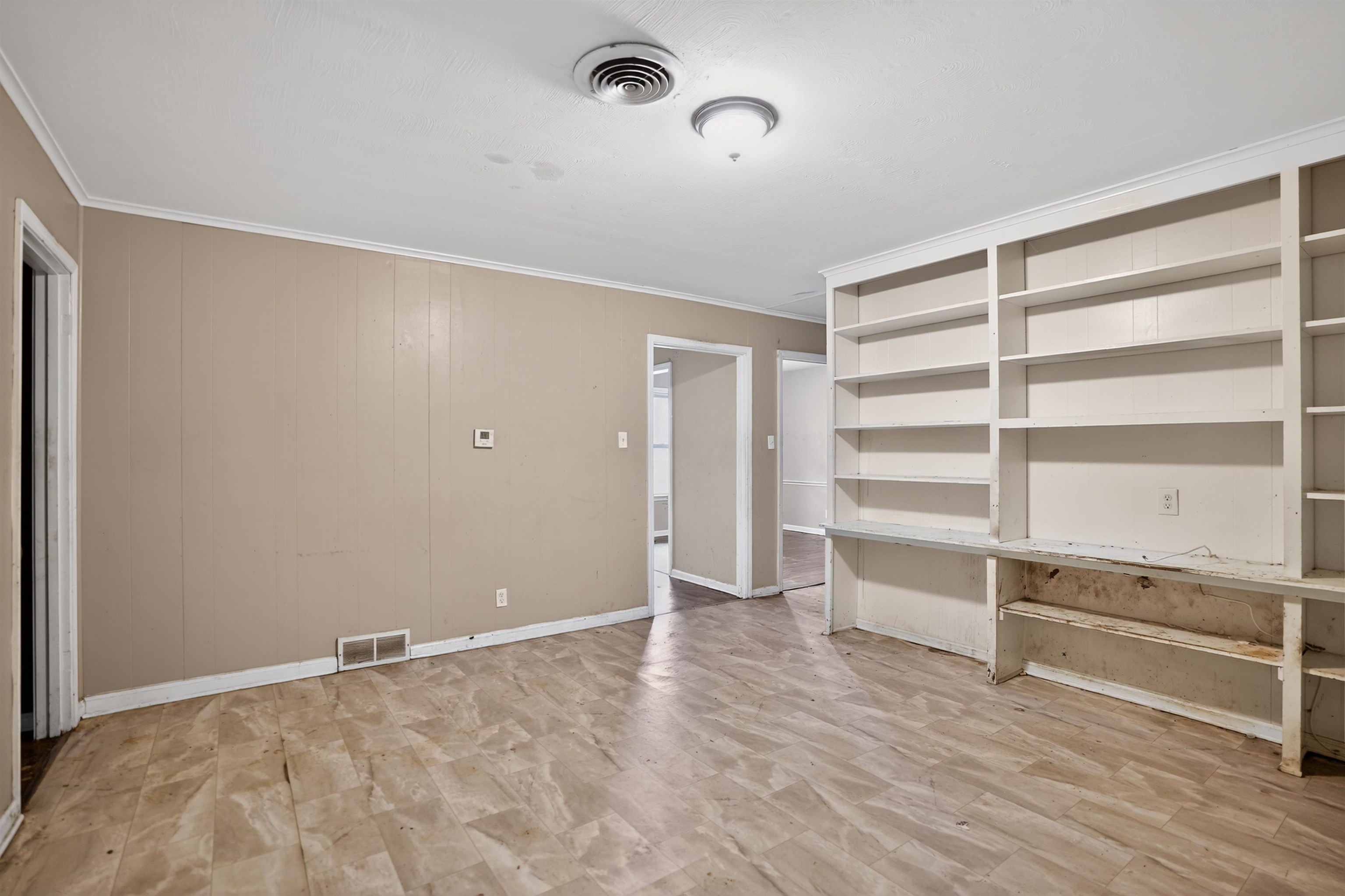 1890 Pennel Road Memphis, TN 38116 - Photo 22 of 25 Interior space featuring extensive built-in shelving, paneling on walls, and ceiling-mounted light fixtures