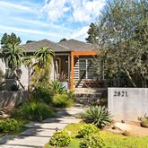 a view of a house with a yard and potted plants