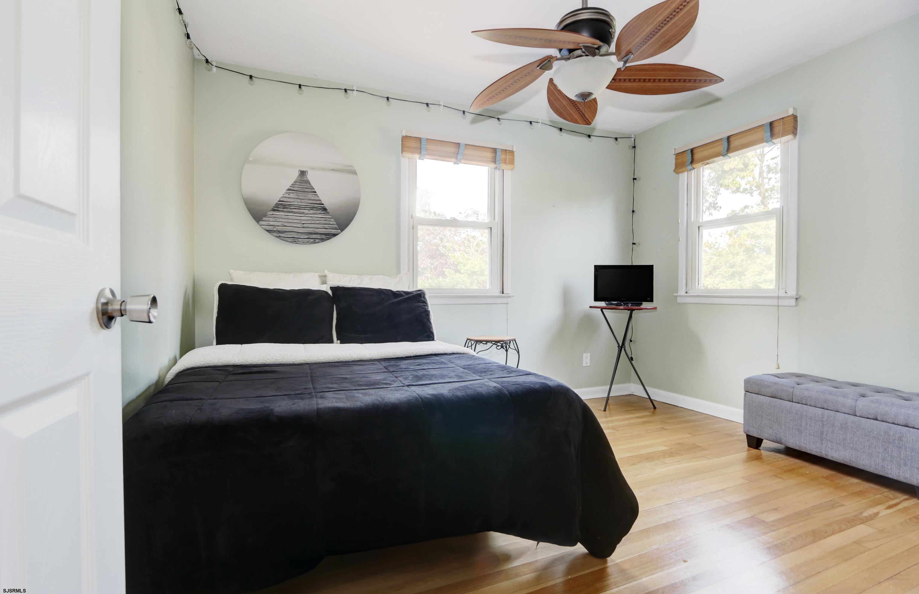 226 Ridgewood Drive Northfield, NJ 08225 - Photo 21 of 41 a bedroom with a bed and a chandelier