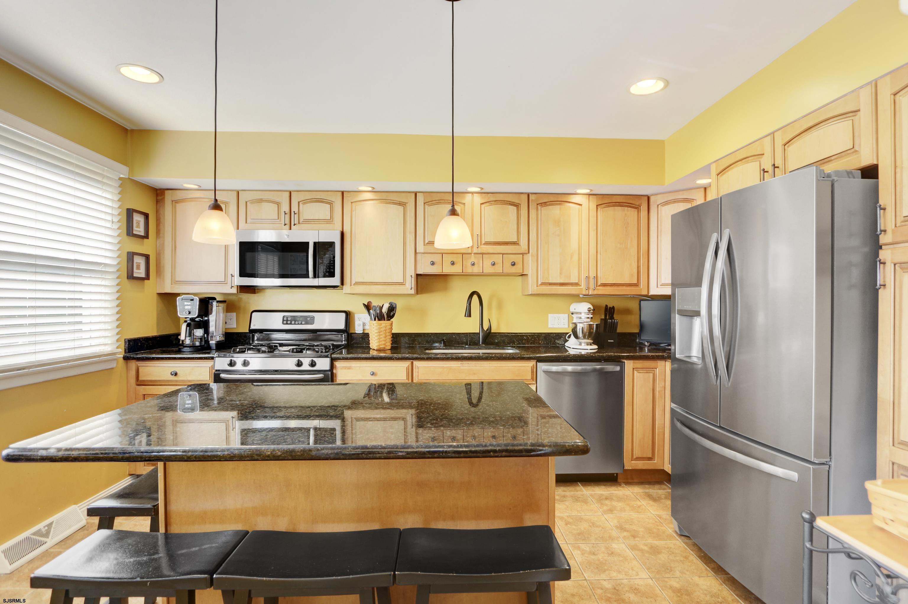 226 Ridgewood Drive Northfield, NJ 08225 - Photo 10 of 41 a kitchen with stainless steel appliances granite countertop a sink a stove and a refrigerator