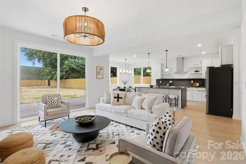 a living room with furniture a flat screen tv and kitchen view