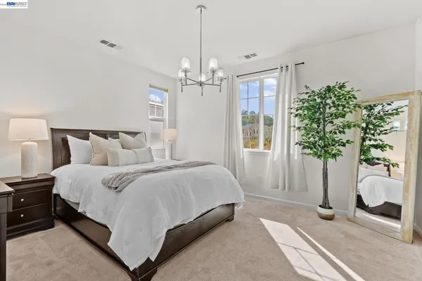 a spacious bedroom with a bed and a potted plant