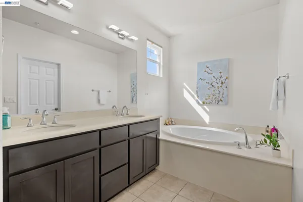a bathroom with a tub sink and mirror