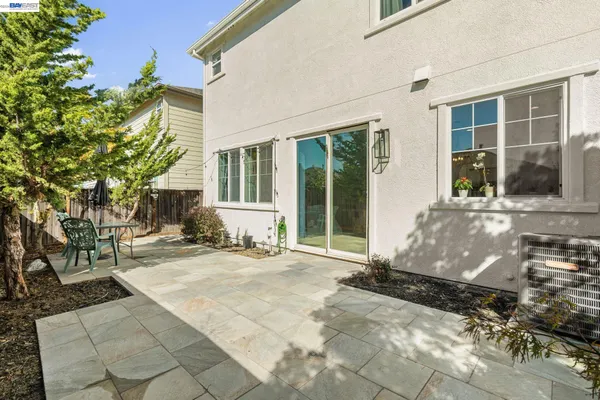 a backyard of a house with table and chairs with wooden fence