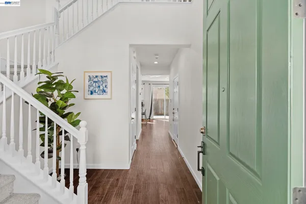 a view of a hallway with wooden floor and stairs