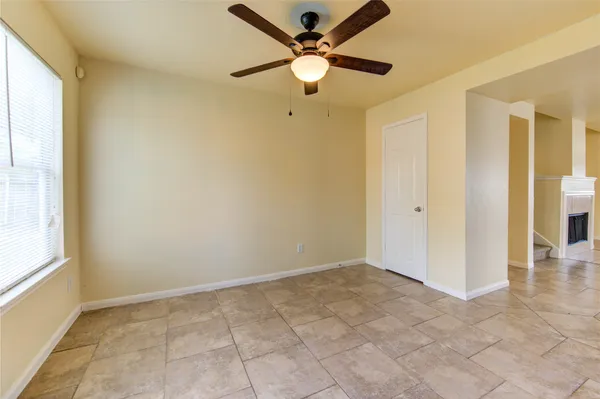 an empty room with fan and windows