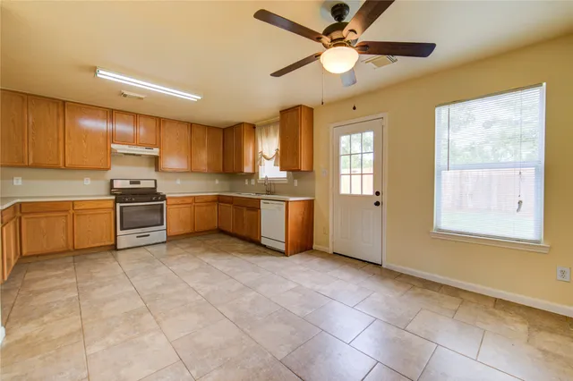 a kitchen with a sink a stove top oven and cabinets