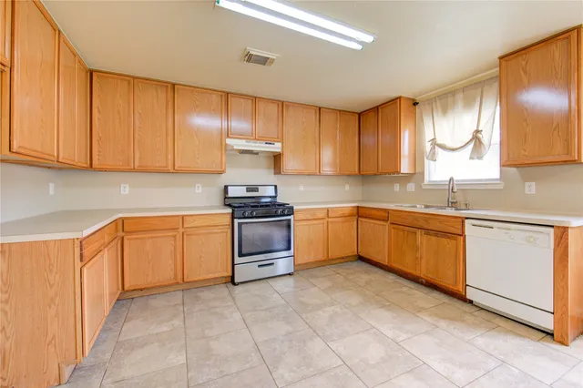a kitchen with a stove sink and cabinets