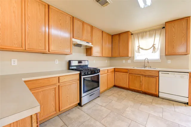 a kitchen with a stove a sink and a refrigerator
