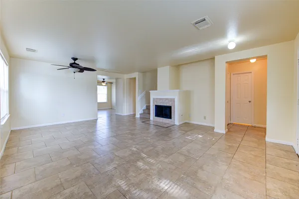 an empty room with fireplace and windows