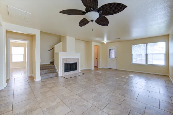 a view of an empty room with a fireplace and a window