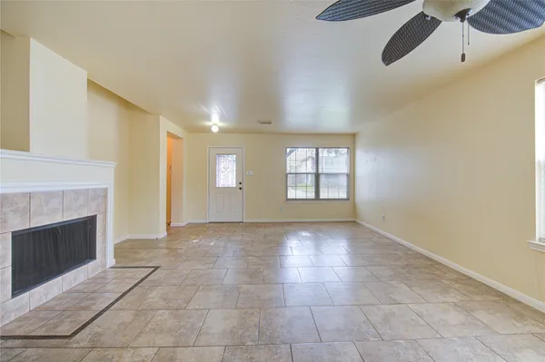 a view of an empty room with a fireplace and window