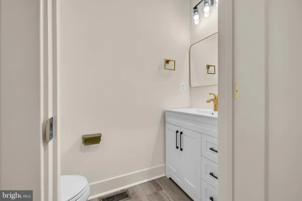 a kitchen with kitchen island granite countertop a stove a sink and white cabinets