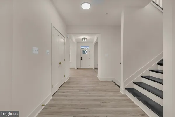 a view of entryway and hall with wooden floor