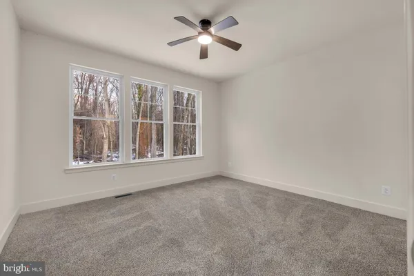a spacious bedroom with a bed and glass window