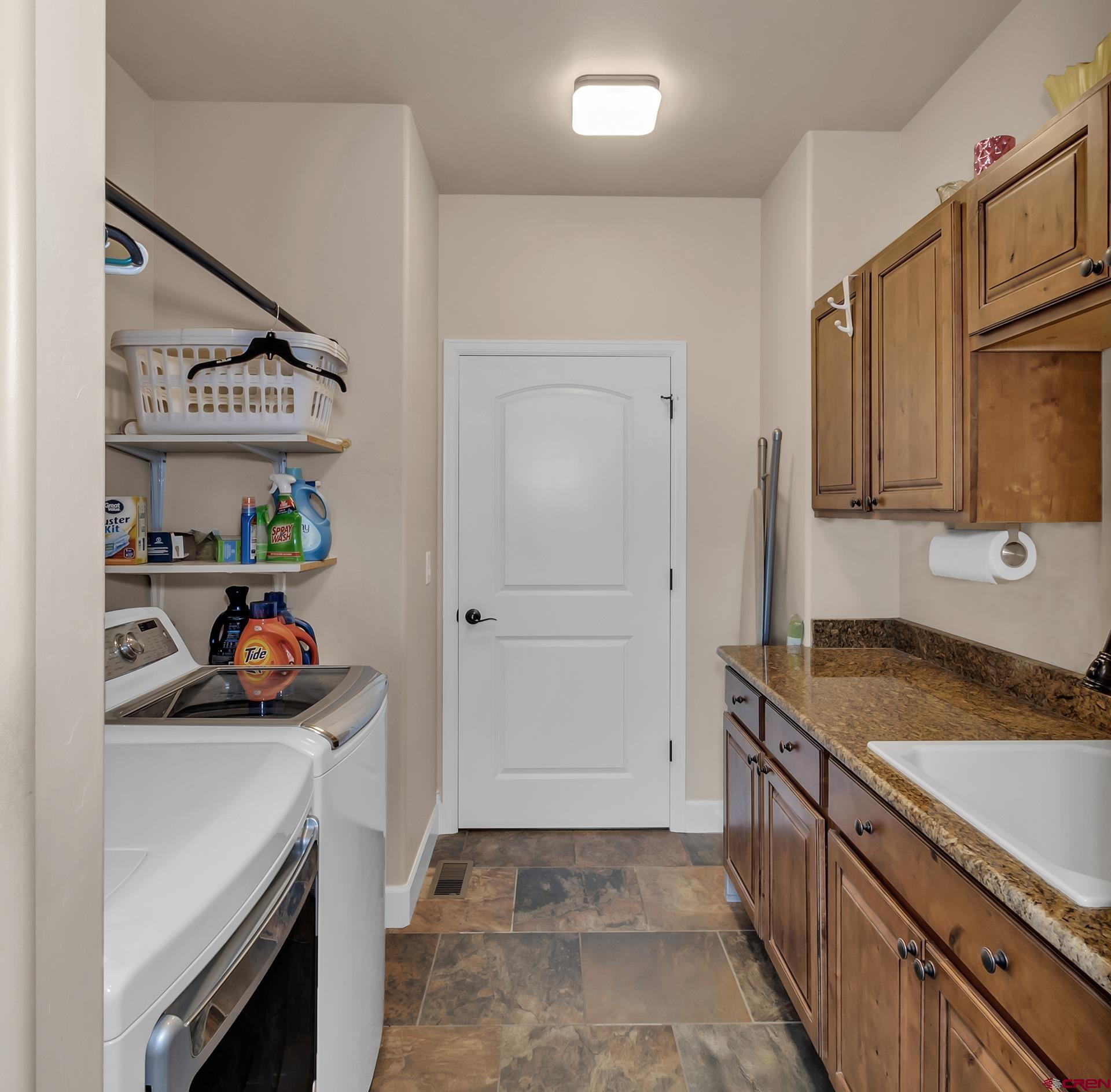8460 1950th Road Austin, CO 81410 - Photo 19 of 35 a utility room with stainless steel appliances granite countertop a sink and a stove