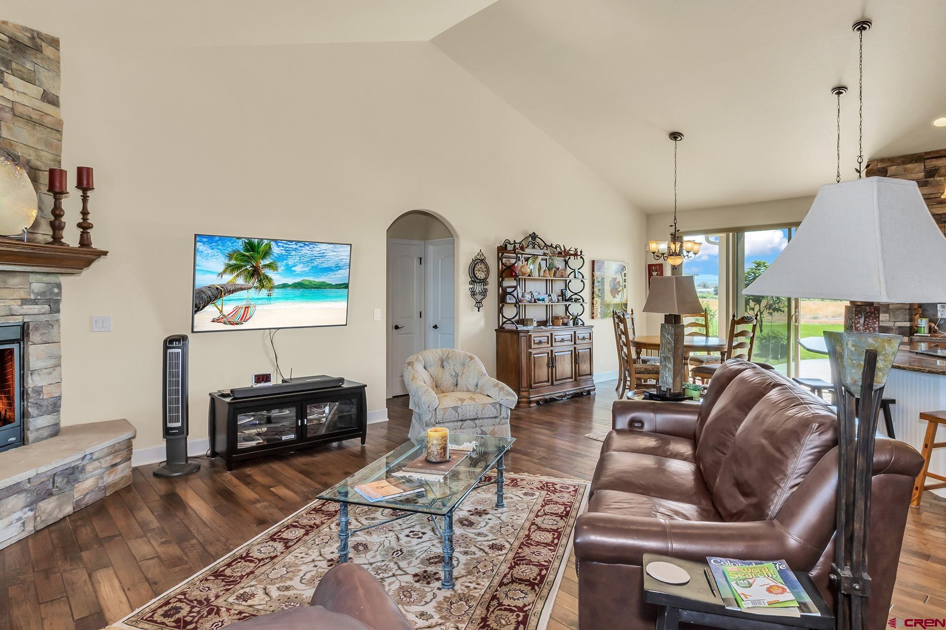 8460 1950th Road Austin, CO 81410 - Photo 5 of 35 a living room with furniture a fireplace and a chandelier